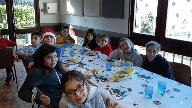 Enfants réunis autour d'un repas de Noël à la cantine