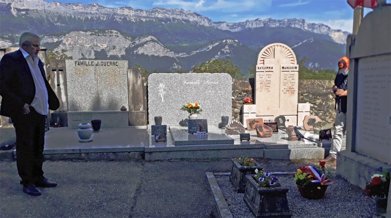 Recueillement devant une tombe fleurie au cimetière de La Pierre, montagnes en arrière-plan