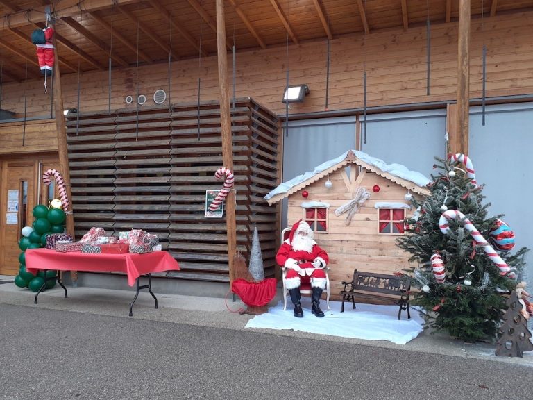 Décorations de Noël devant un bâtiment communal, avec un Père Noël et un sapin
