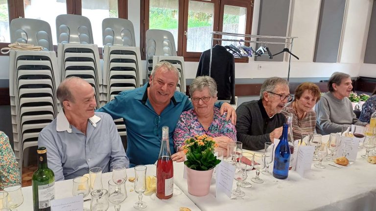 Convives souriants lors d'un repas convivial à la salle communale