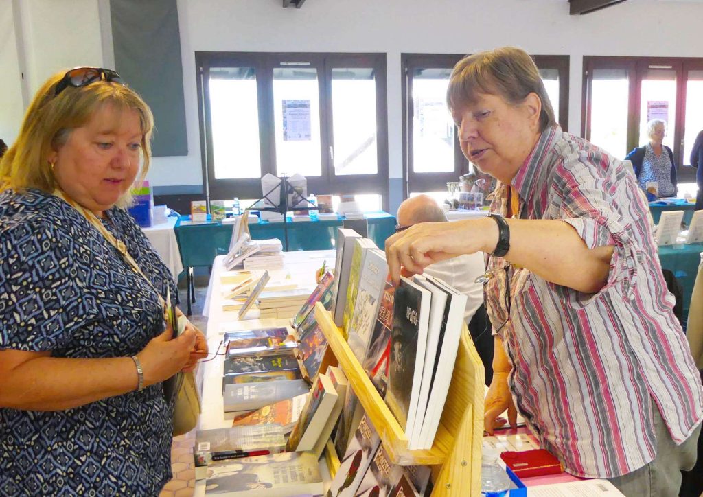 Deux visiteuses consultant des livres lors d'un salon du livre